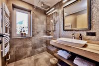Badezimmer mit braunen Fliesen verlegt im Apartment Deluxe an der Zugspitze